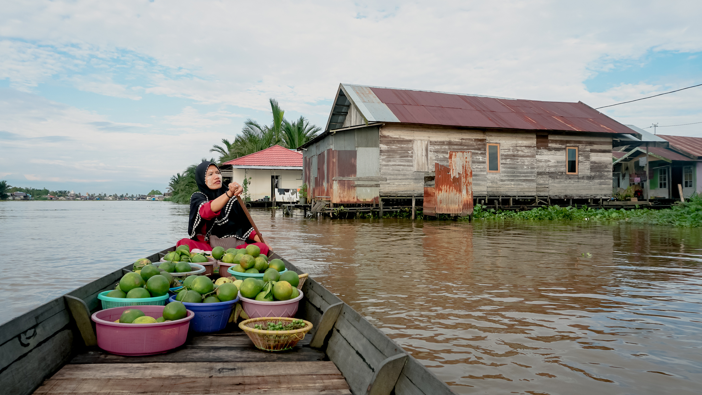 Floating market seller paddling a boat to Lok Baintan floating market, South Kalimantan